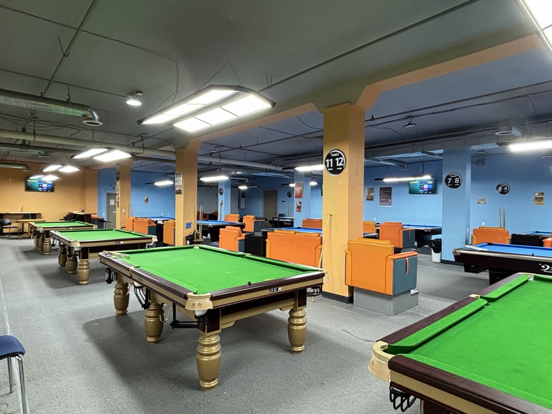 Wide view of 24Billiards pool tables.